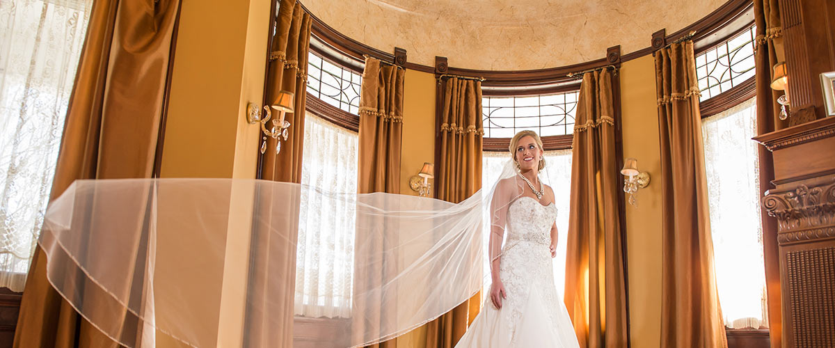 bride in wedding dress in front of windows