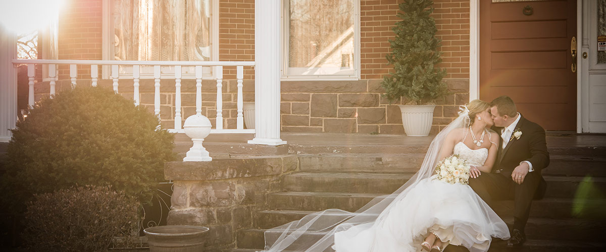 Bride and Groom sitting on steps of mansion porch