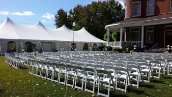 exterior view of mansion with chairs and tent setup for wedding