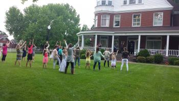 mothers and daughters dancing on the lawn at the mansion
